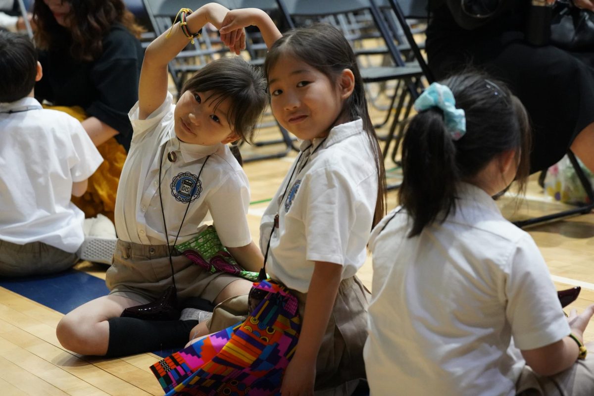 Elena Kim and Evelyn Choi in first grade grade boast their friendship with a coordinated heart. Their bond helps them relax before their choir performance. 