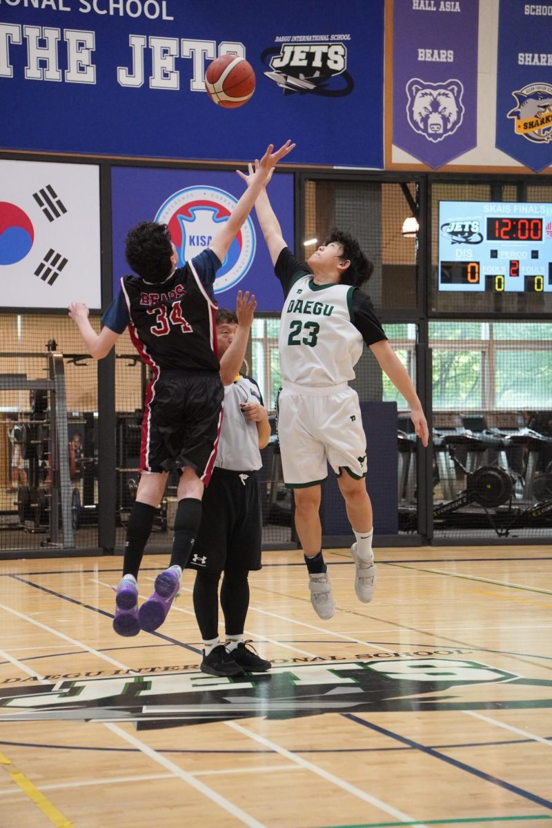 Center Charlie Park (number 23) leaps to grab the ball during a jump off against the ISB center. Using his immense vertical, he tips the ball towards his teammates. 
