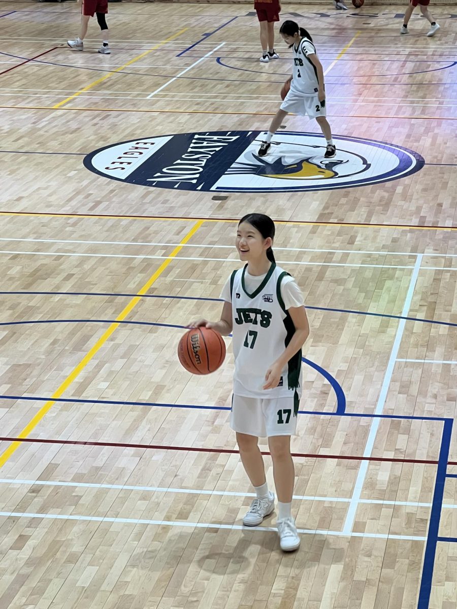 Olivia Park (17) practices her shooting and layups with focused intensity during warm-ups. She works on perfecting her technique to prepare for a strong performance in the game ahead.