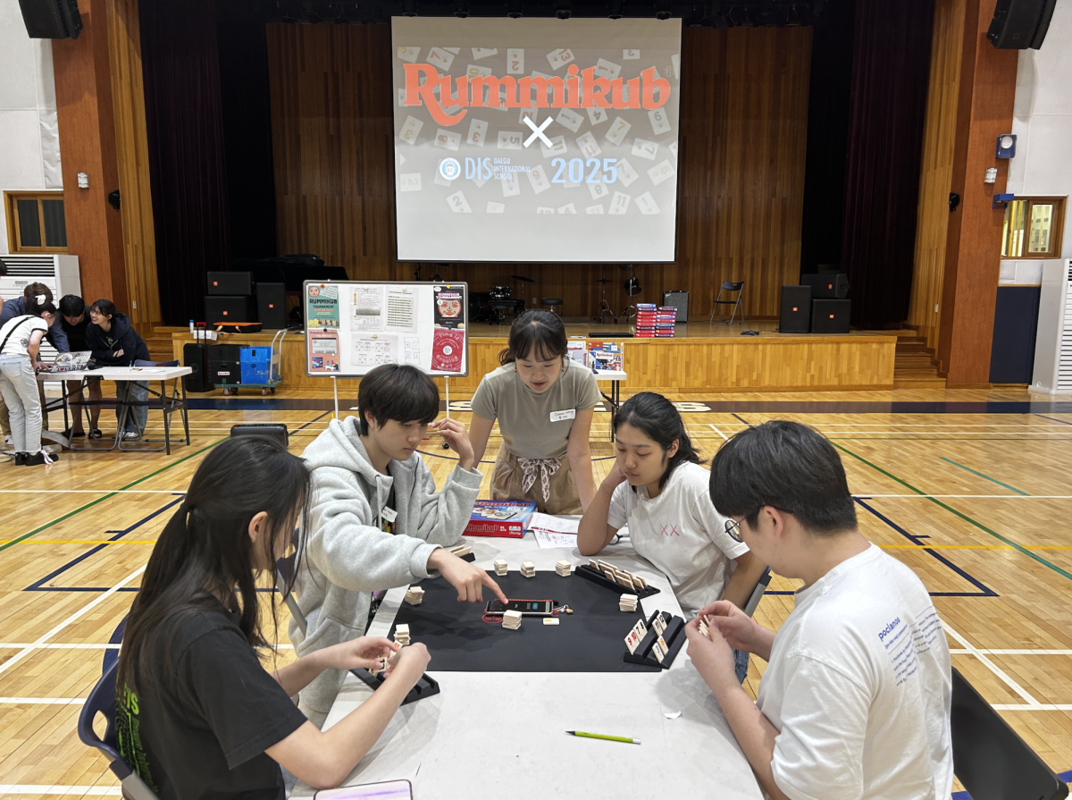 The final four gear up for one last game of strategy and skill while coordinator Ms. Wang adeptly manages the round.