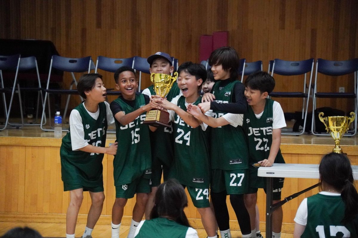 The boys A team hold up the trophy after their final game of the season. Their win marks a strong finish to the year.