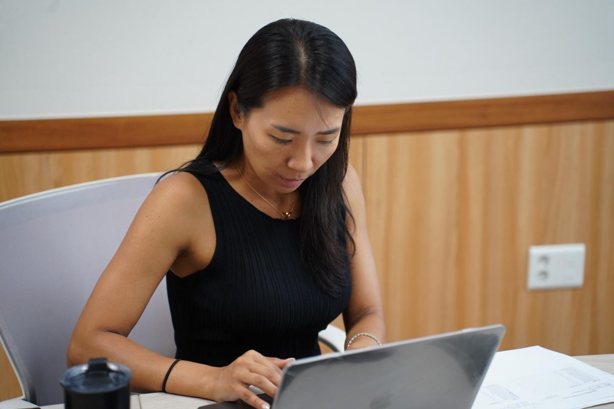 Marketing Specialist Ms. Katie Kim checks students off the list. She ensures each student receives a spirit shirt with care and precision. 