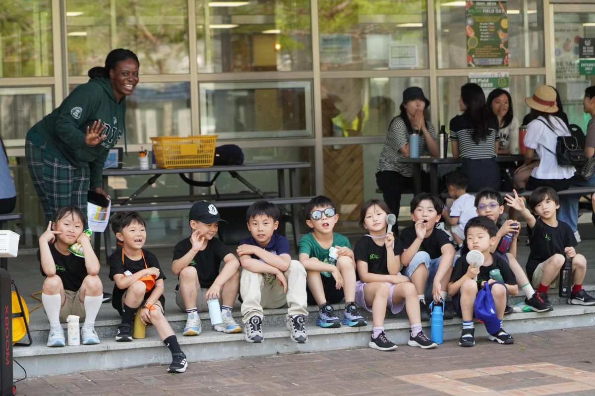 The first grade class rests from the heat with a cool breeze from their mini fans. After a quick break, they run out back to the fields to run around.