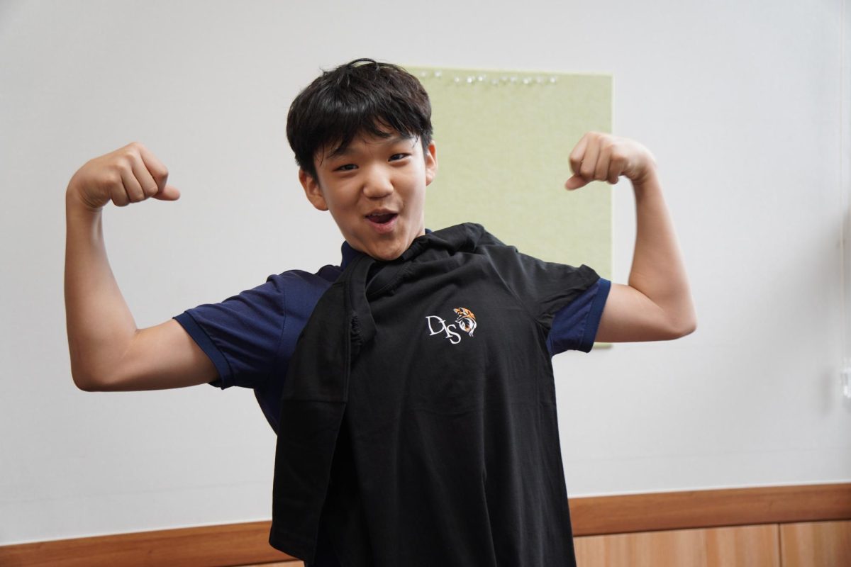 Seventh grader Steven Jang flexes with his new spirit shirt. He and his Learning Lab pals grabbed their new gear in the conference room during the first week of school.
