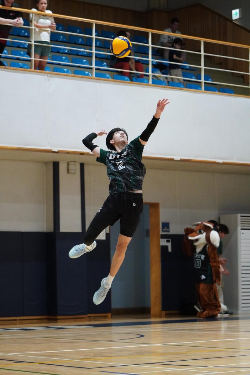 Outside hitter Evan Rossmeisl (2) leaps forward to unleash a powerful float jump serve. His precision allows the ball to drop right in front of the opponents’ defensive positions. 
