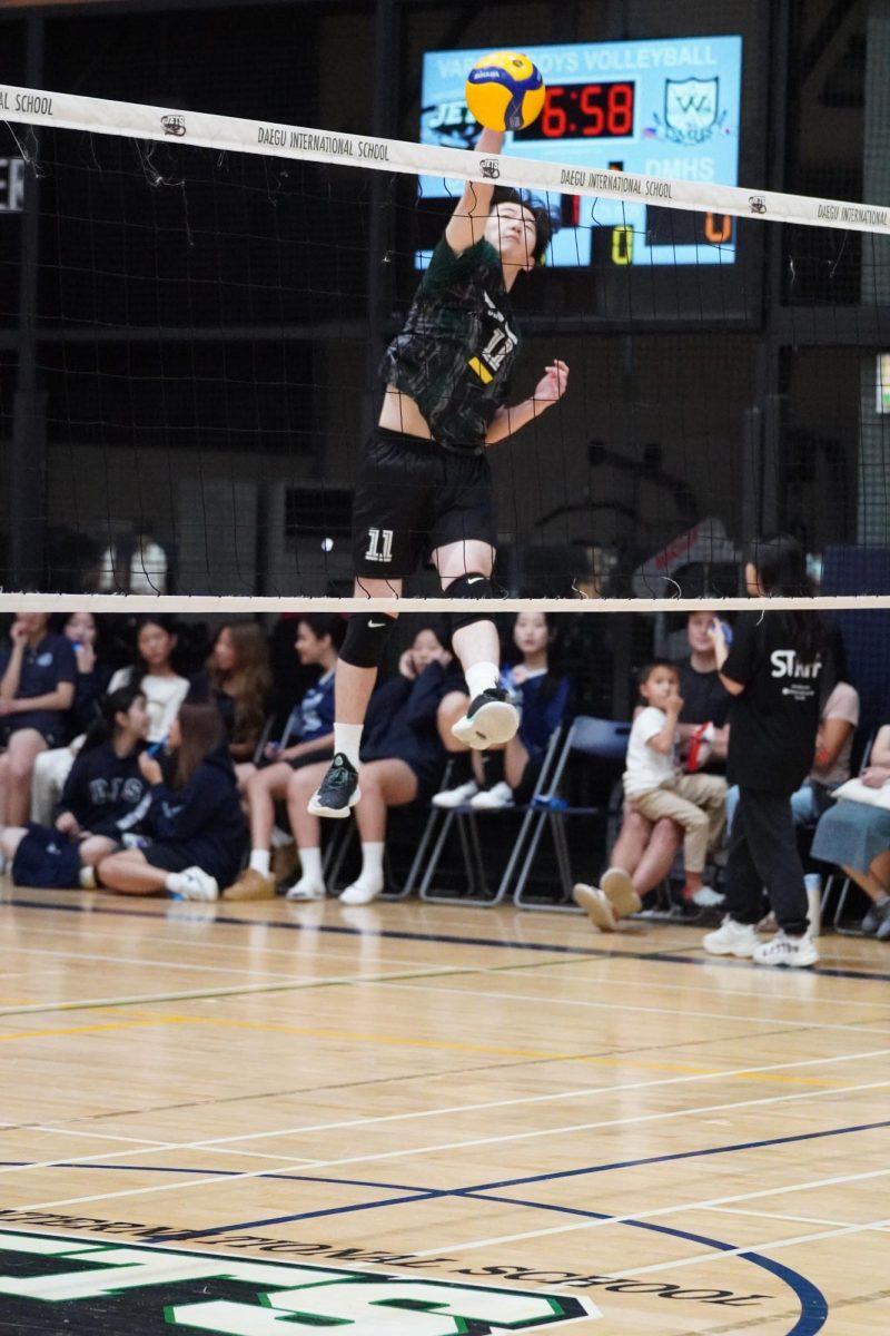 Outside hitter Brandon Hyun (11) floats up with his immense vertical to hit a cross. Now, as a veteran senior athlete, he leads the group of sophomores and juniors in the varsity squad.