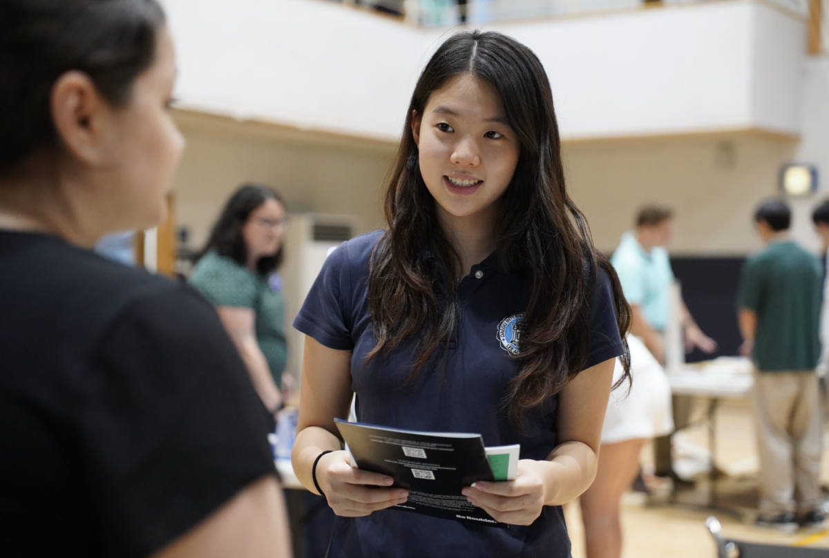 Junior Leewen Wang engages in an insightful conversation about the admissions process with a college official from the University of Colorado Boulder. Her attentive expression reflects both curiosity and enthusiasm as she learns more about potential opportunities for her future.