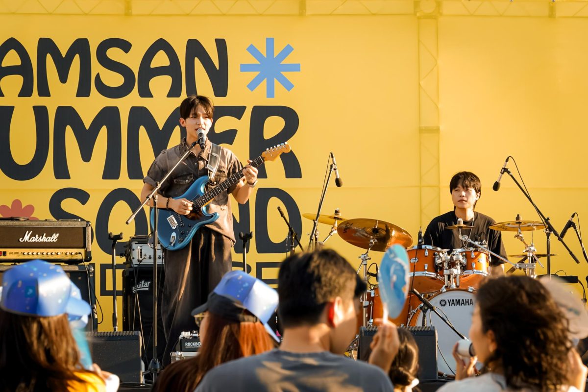 Even through the dire heat, Tipsy’s guitarist and vocalist strums along to “Congratulations” by Day 6 with a smile on his face. Audience members can be seen wearing Tipsy-branded hats, as they nod along to the music. 
