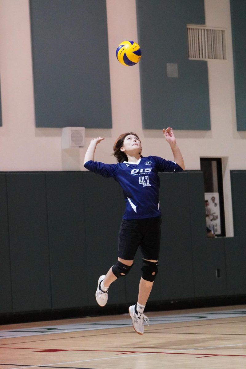 Junior Jayden Hayward (41) sticks her tongue out in focus as she tosses the ball high. With a sharp swing, she delivers a blistering serve that drops untouched for an ace.