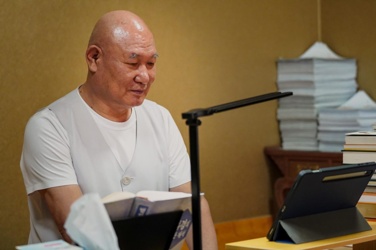 Il-woo at his desk—his daily ritual now includes both Buddhist chants and chapters from a psychology textbook. Photo by CJ Park.  