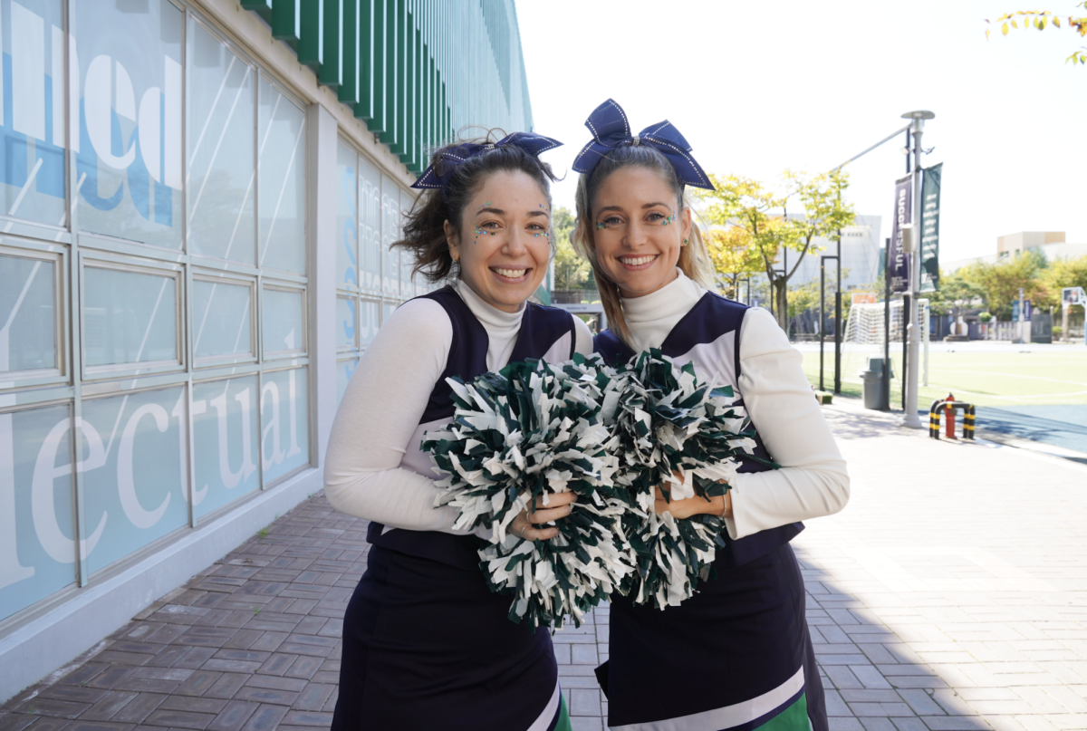 Elementary art teacher Mrs. Gum and second grade teacher Mrs. Kaschub light up the field in their cheer uniforms and matching bows. Their enthusiasm and team spirit bring extra cheer to the school community.