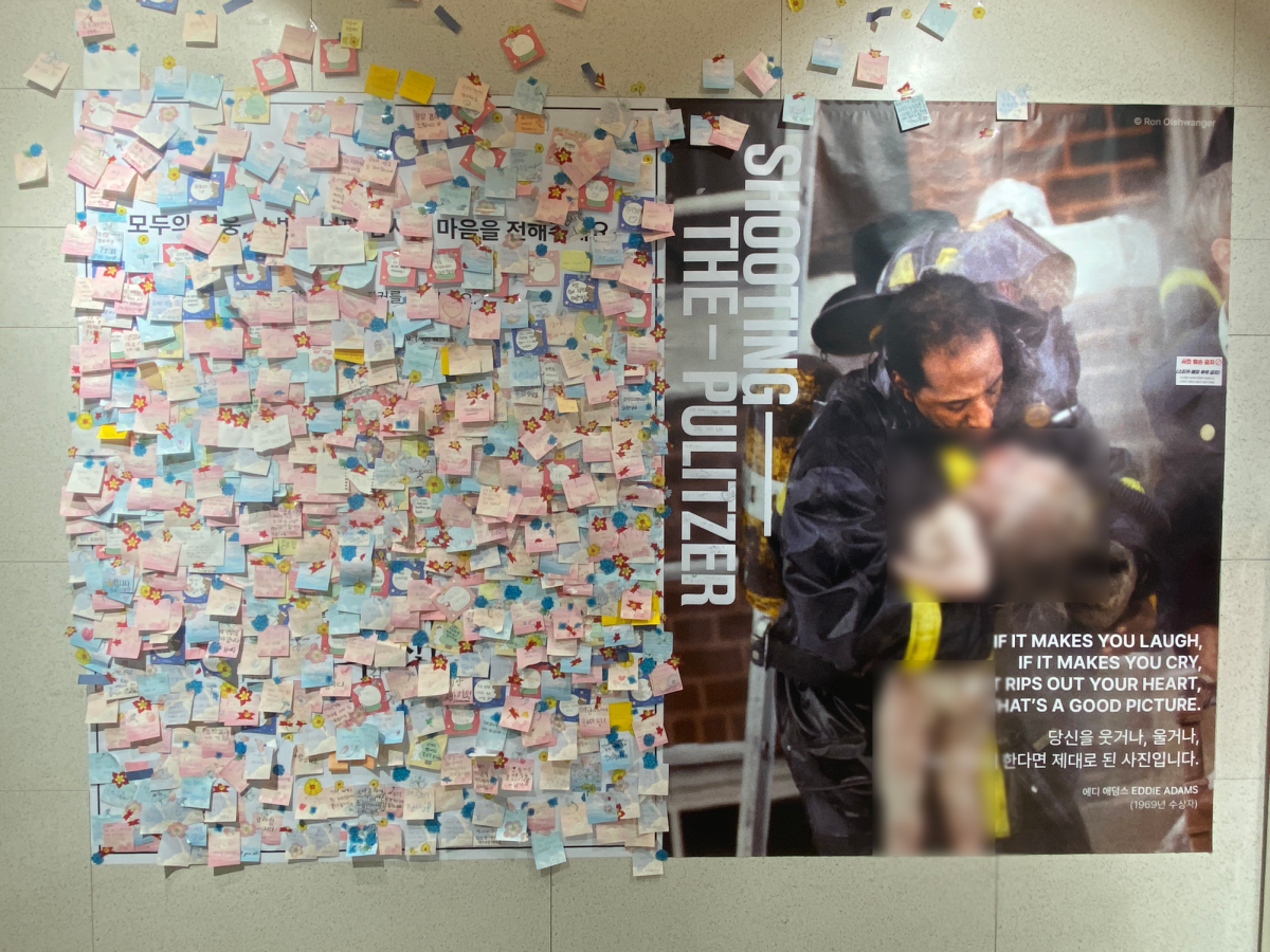 Visitors record their impression of the exhibit on stick notes and display them on the comment board. Adjacent to a recent Pulitzer-winning photo, the messages embody the emotional impact of the photos.