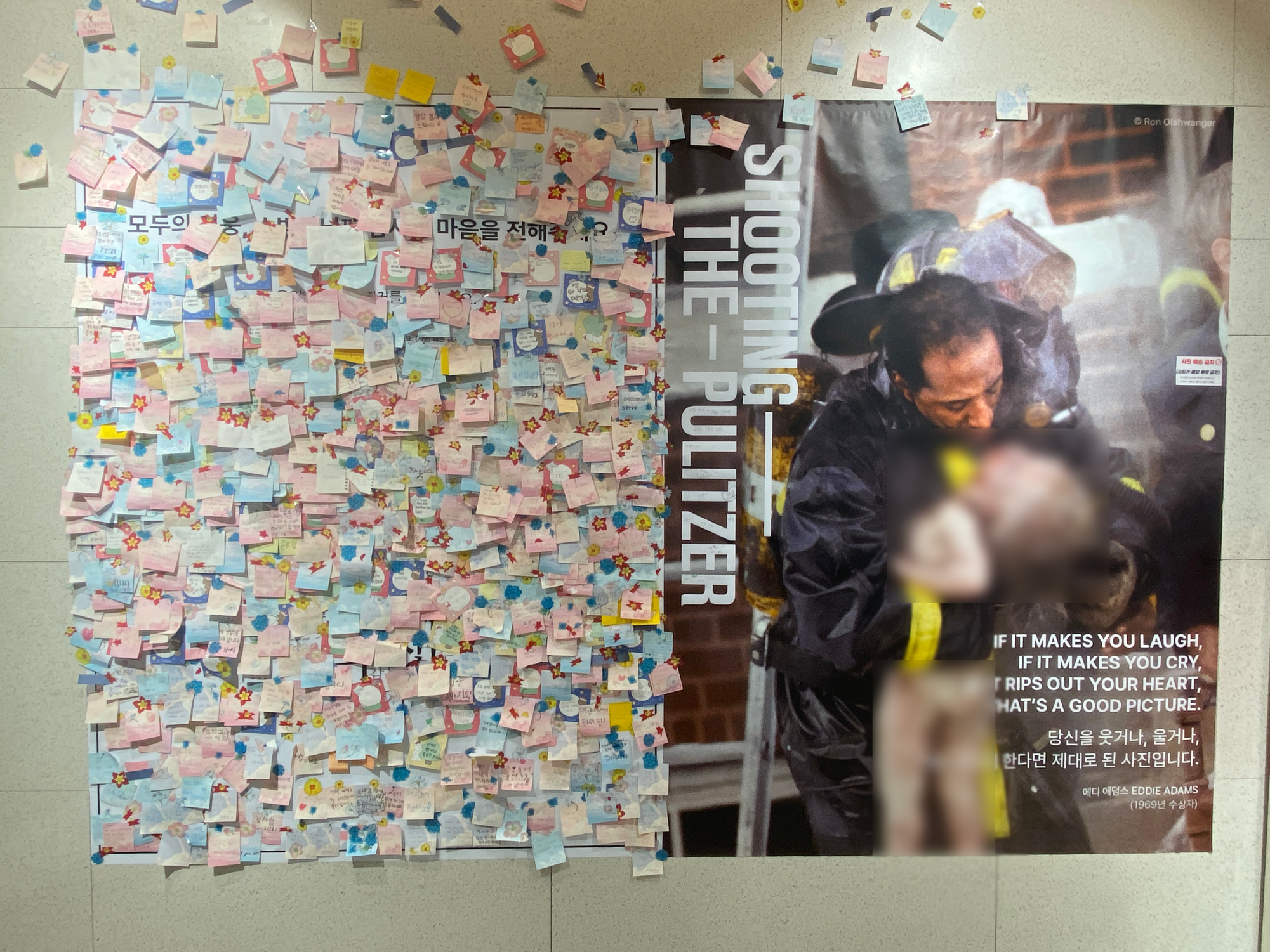 Visitors record their impression of the exhibit on stick notes and display them on the comment board. Adjacent to a recent Pulitzer-winning photo, the messages embody the emotional impact of the photos.