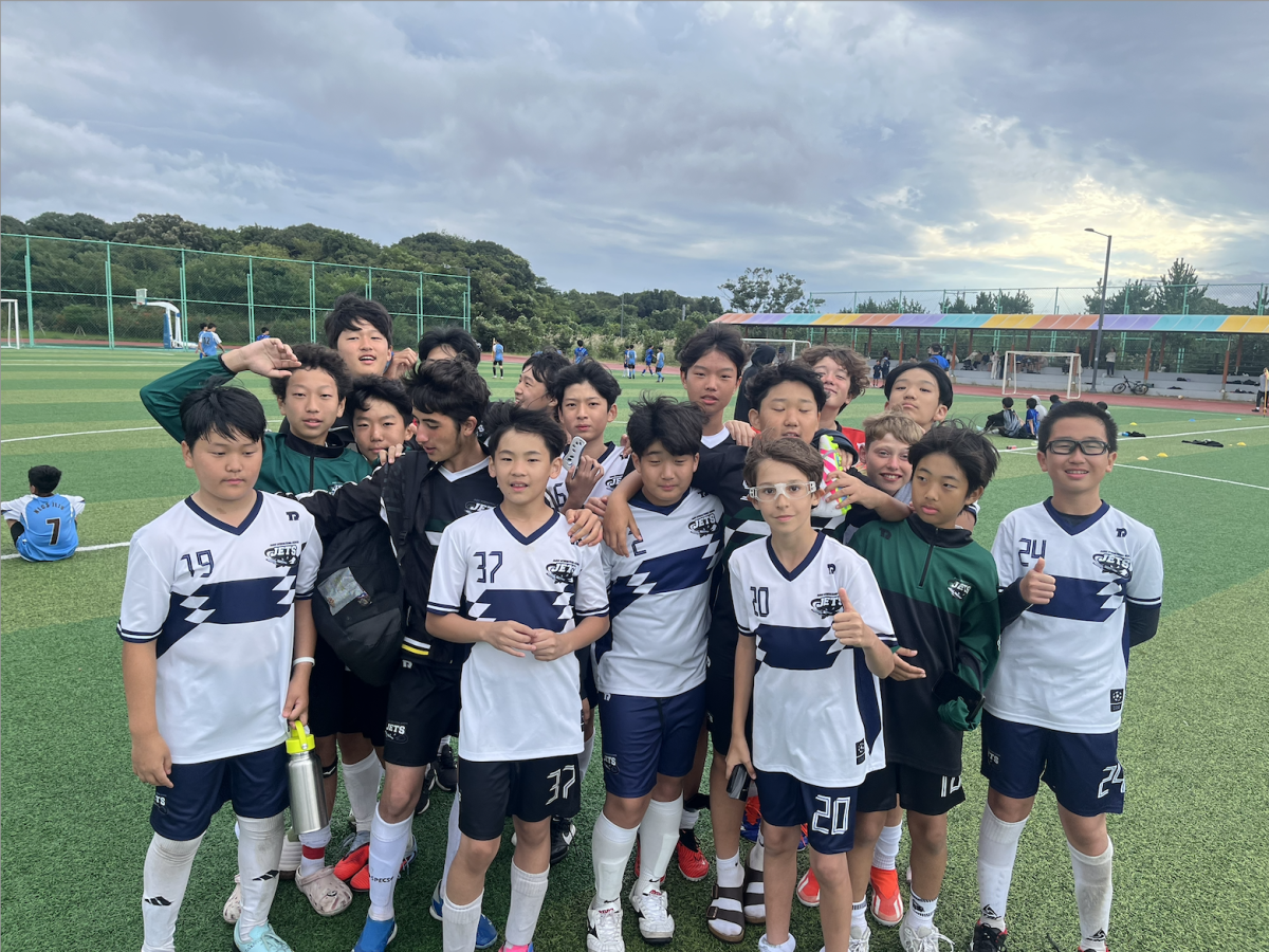 The middle school boys KISAC soccer team link arms and grin from ear to ear. Sweaty and exhausted, they celebrate a hard-fought game. Photo courtesy of Mr. Crewe.