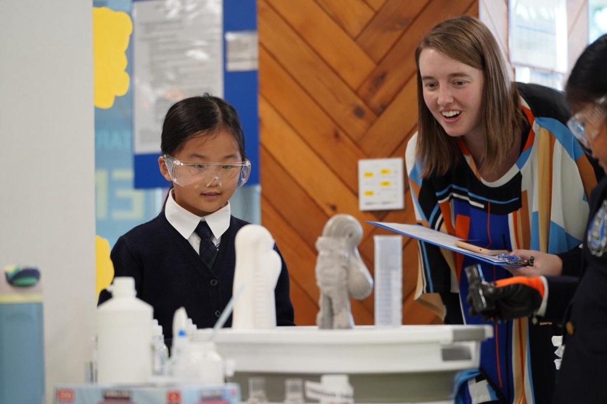 Third grader Elena Byeon examines the exhibition with Ms. Nagy. Her focused gaze signals growing curiosity about the topic.