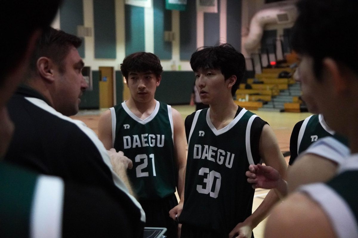 Coach Kaschub calls a timeout to recall the in-game plays. Chris Ryu (30) and Noah Hwang (21) listen closely, executing the tactics in real game situations.  
