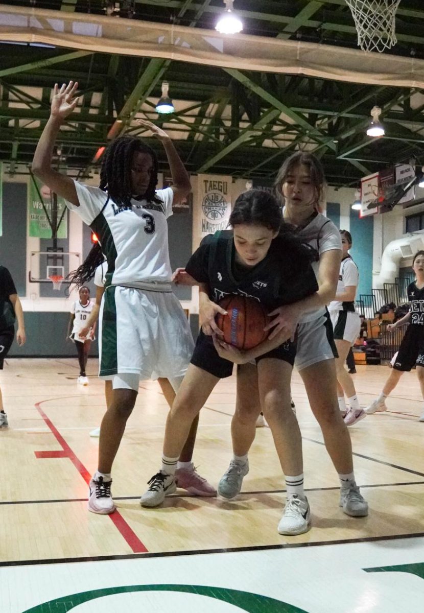 Luisa Silva (34) fights for the ball, holding tight as two warriors rush in. She holds her ground and urgently looks fro a way out