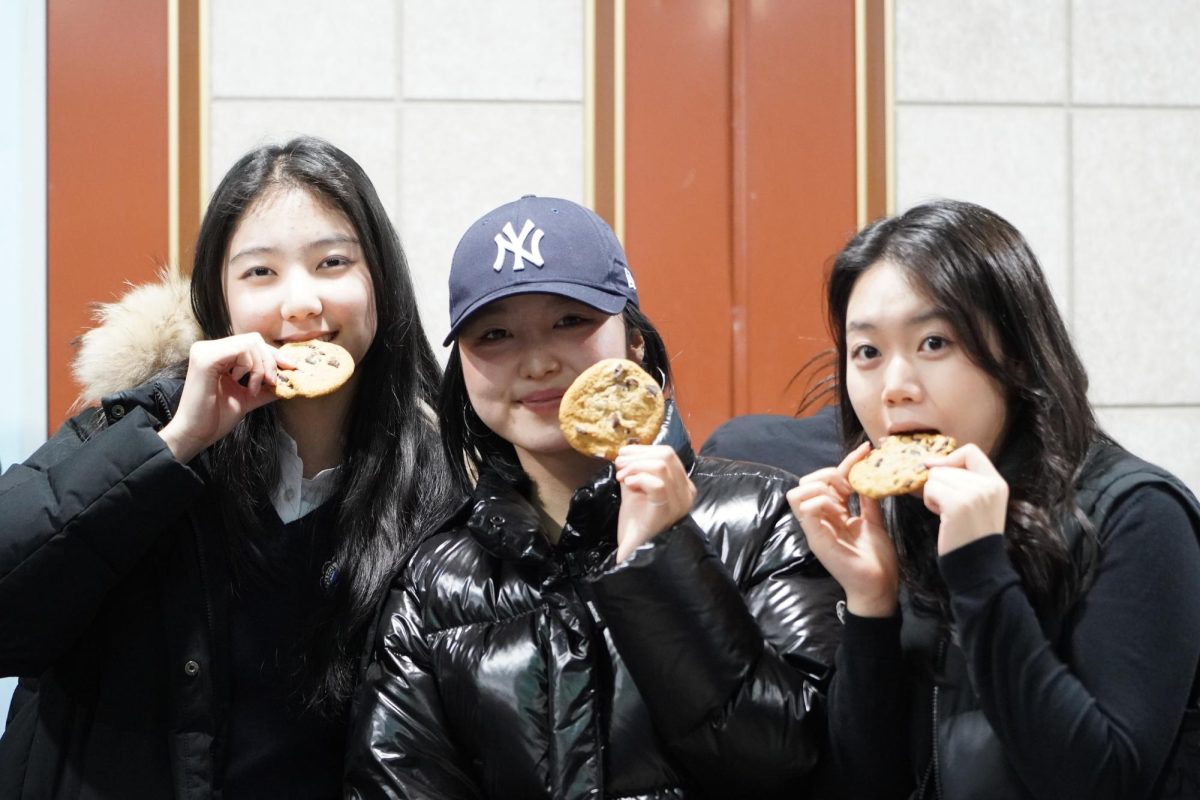 Juniors Sally Lee, Lucy Kim, and Belle Kim anticipate a crisp bite of their cookies. After exploring the cookie-decorating booth, they finally appease their sugar cravings. 