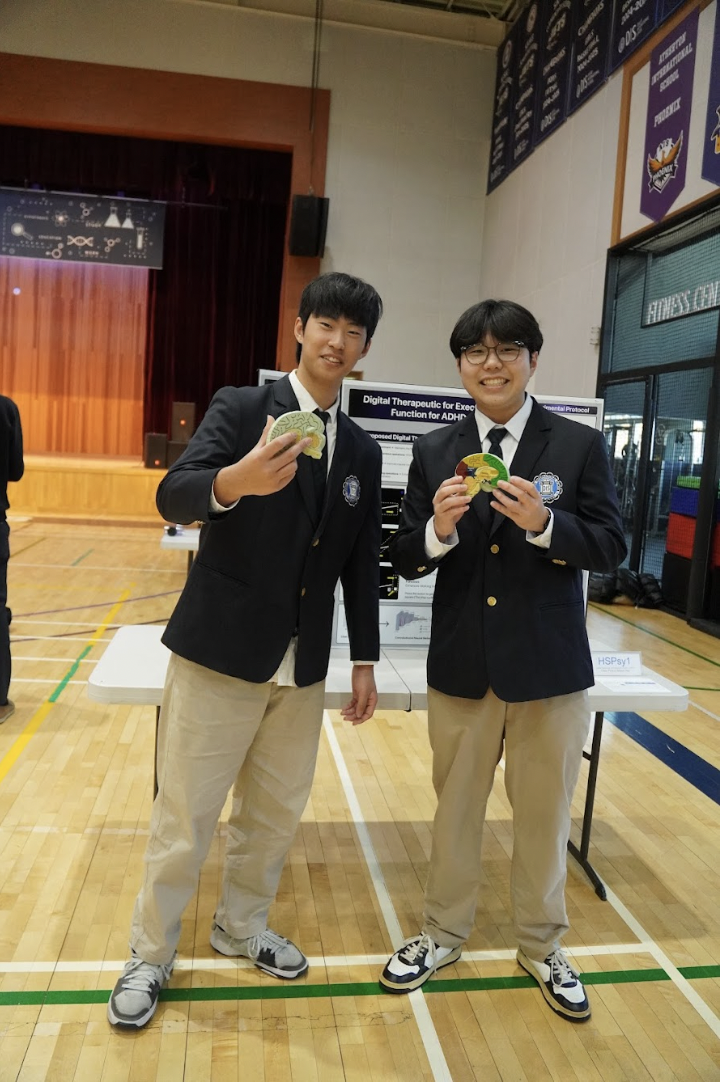 Sophomore William Seo and junior Oliver Park proudly show off their 1st place winning project. Seo and Park's experiment uses brain models to elaborate digital therapeutic for executive function for ADHD. 