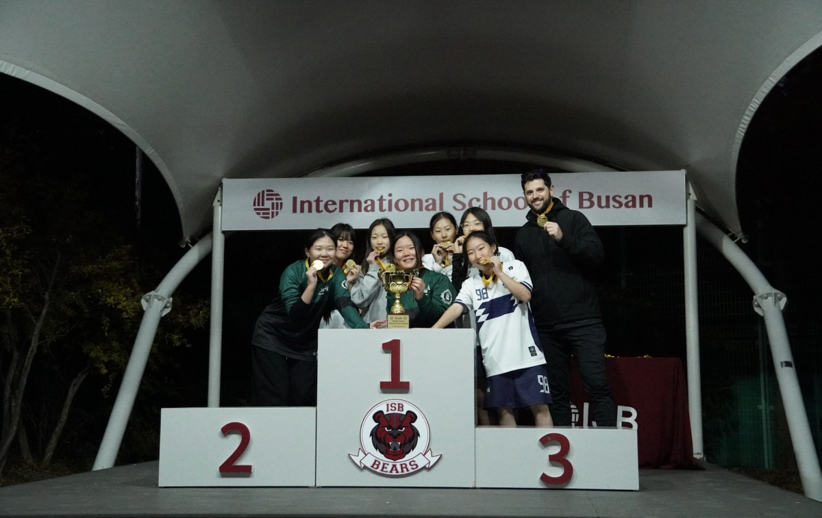 The JV girls raise their gold medals and tournament trophy after the championship match. Their celebration marks a strong finish to a demanding day of competition.