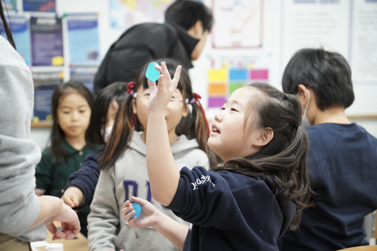 Emma Lee in second grade holds up her own clear-blue bouncy ball with pride. The activity allowed students to experiment how different materials combine to create an elastic mixture.