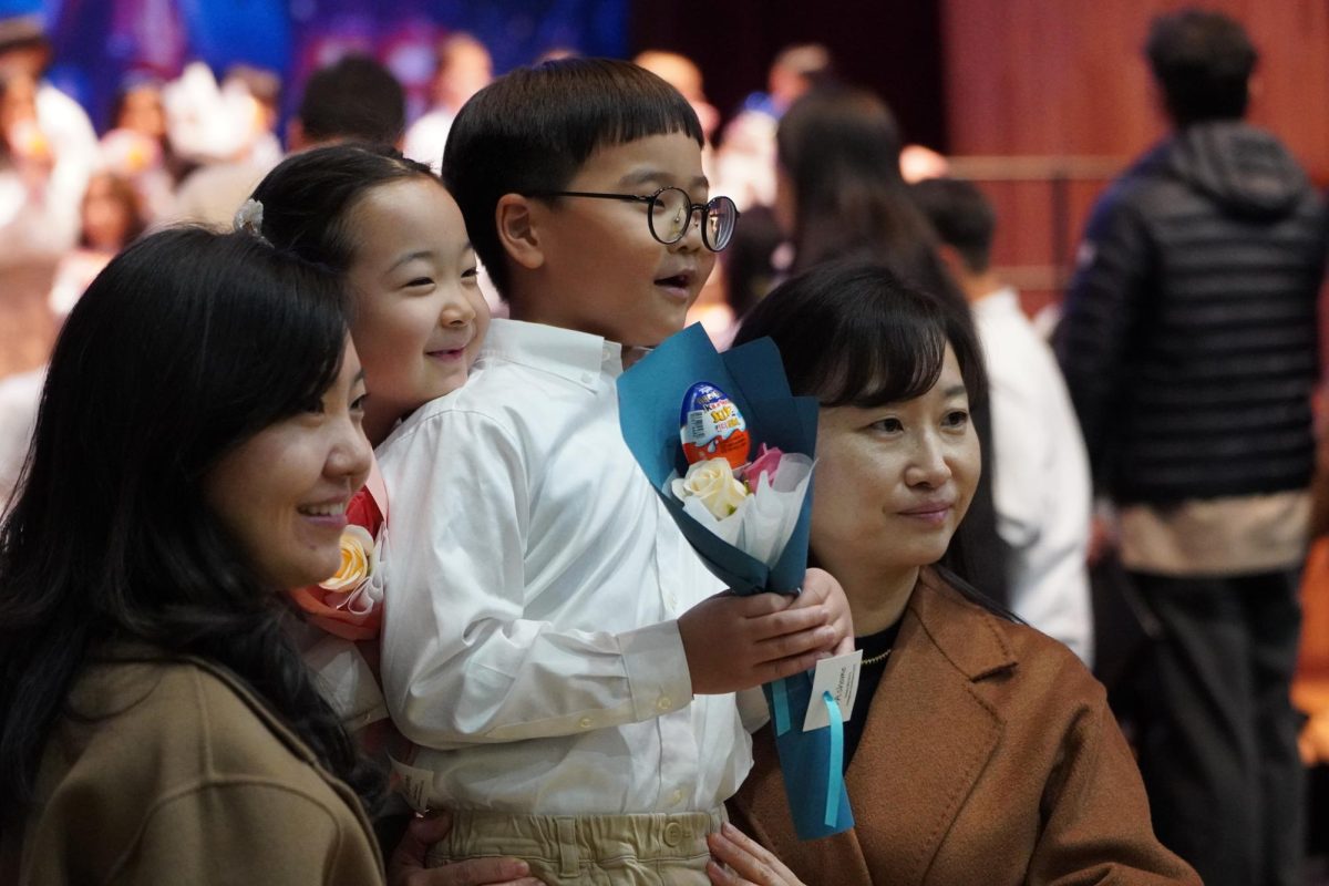 Jun Cho in first grade receives a bouquet from his family members, sold by the Ambassadors club. As the splendid night comes to an end, parents, teachers, and students leave satisfied with the show.