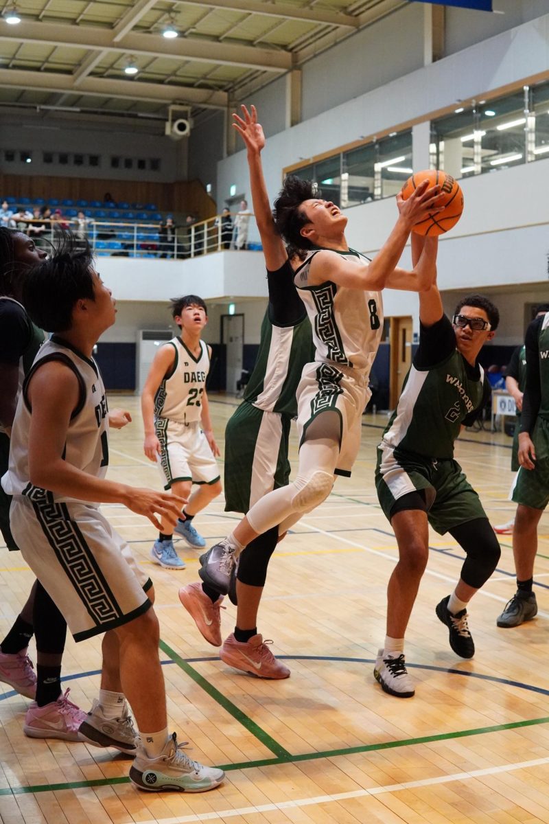 Point guard Jason Kim (8) drives toward the basket for a layup and gets in contact with the defender. He stays calm as the referee calls a foul in his favor, preparing for a free throw.