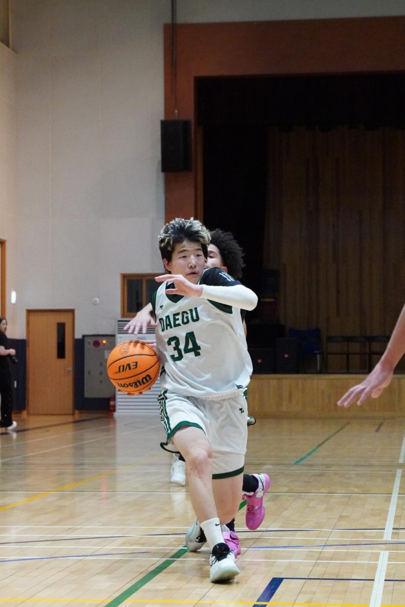 Point guard Joseph Yoon (34) takes the ball from half court with his stable dribbles. He maintains control over the ball to set up the next offensive play.