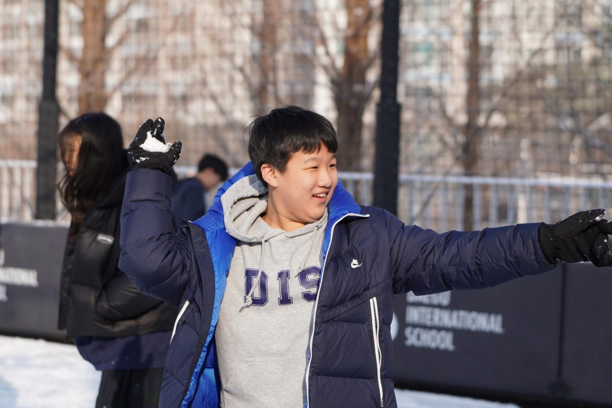 Seventh grader Dylan Li holds up his arms and draws back his right hand, aiming before launching a snowball at his friends. Excitement sparks in his eyes as the playful battle erupts.