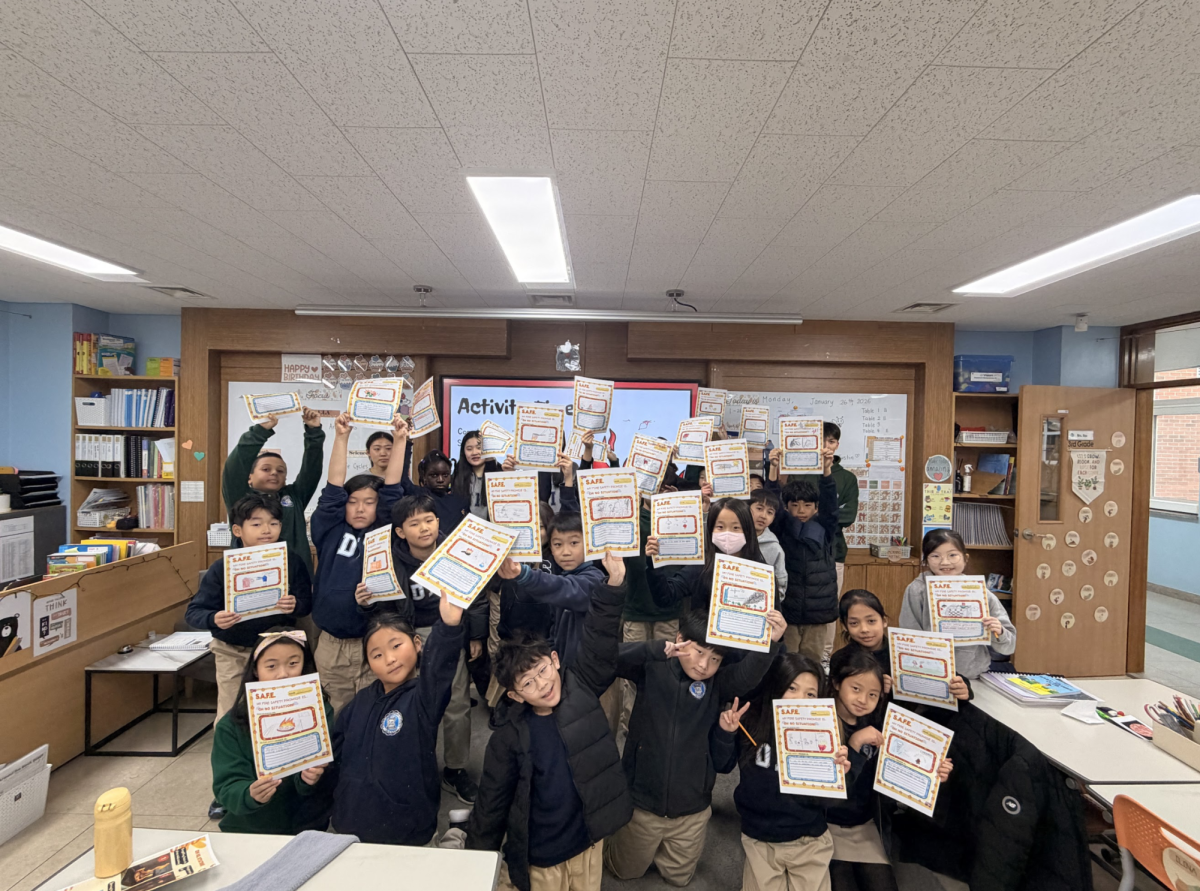 The third grade class holds up their “Fire Safety Promise” worksheets, each one meticulously drawn and filled out utilizing their newly gained knowledge.
