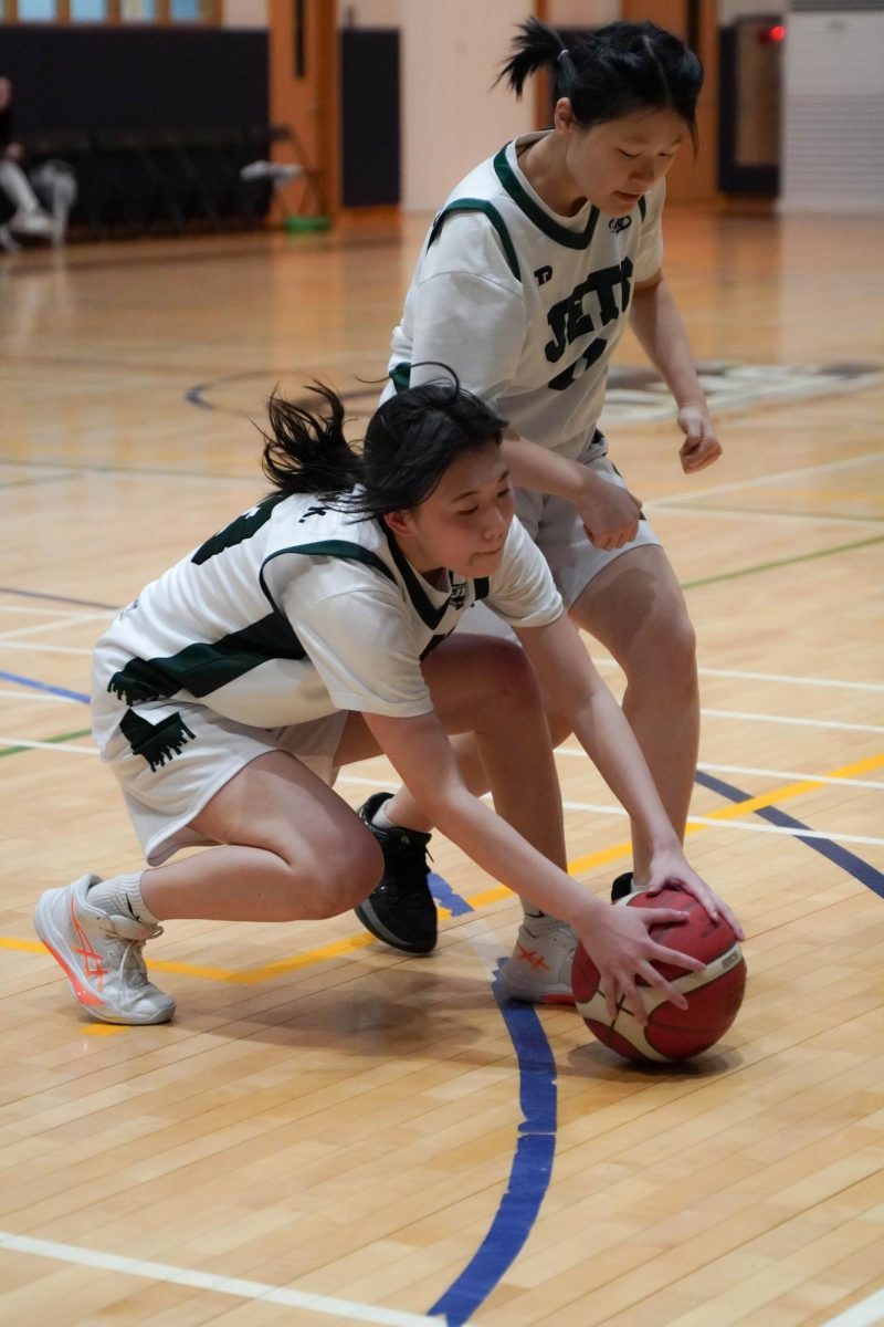 Small forward Juyeon Kim (24) and power forward Sophia Bae (11) dive into the scramble, both fighting for control. Kim (24) lowers her stance, secures possession, and quickly whips a pass to the weak side to reset the play.