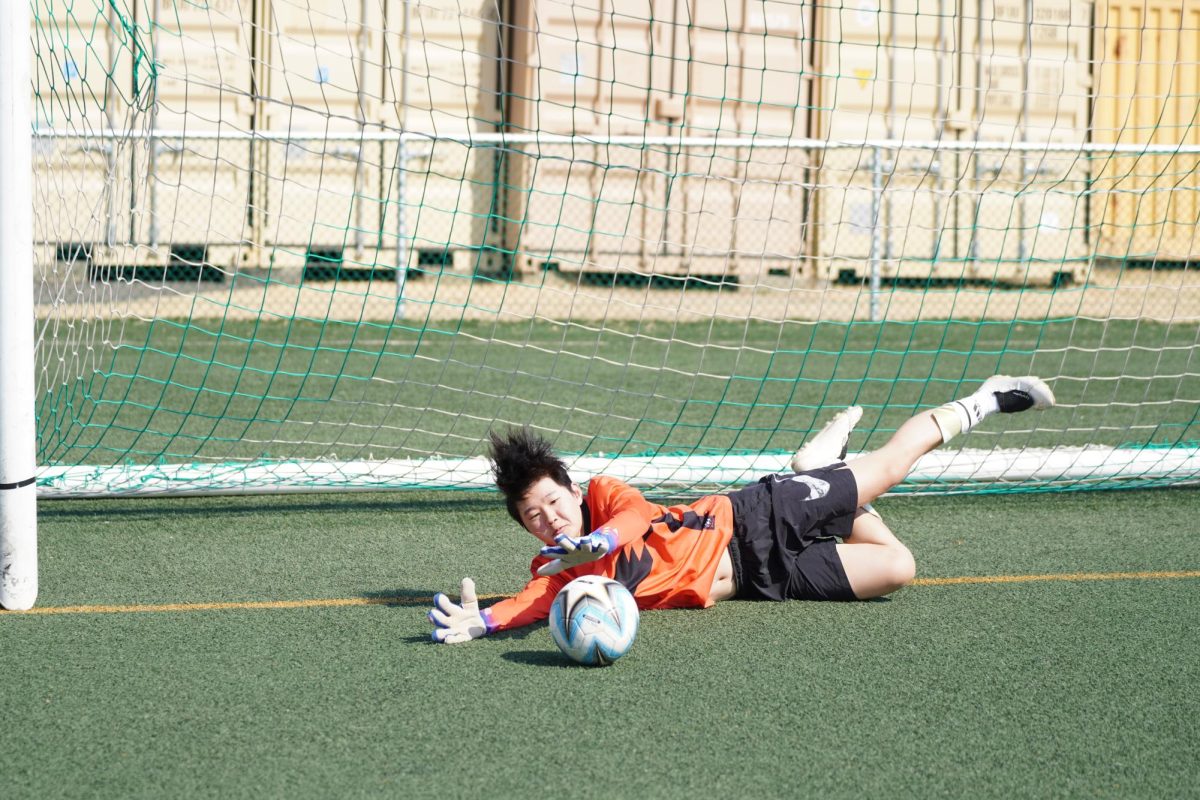 Goalkeeper Jason Kim (56) dives to his side and gets a hand to a shot headed for the corner of the goal. His crucial save preserves the one-goal lead for the Jets and lifts the team’s energy.