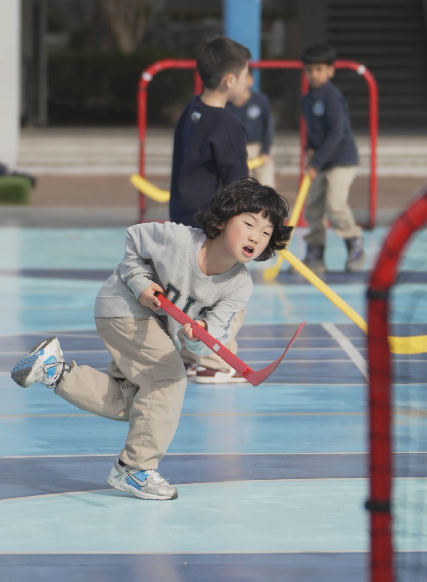Siho Kim from first grade sweeps the puck with all his strength – his determination reflecting how the ASA trains the students’ mentality