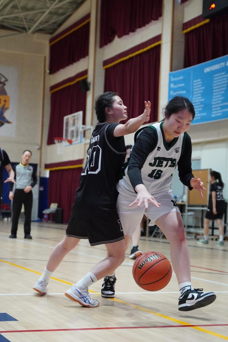 Power forward Amy Shim (18) takes one dribble past her defender before driving toward the basket. She powers through contact as she attacks the rim for a scoring opportunity.