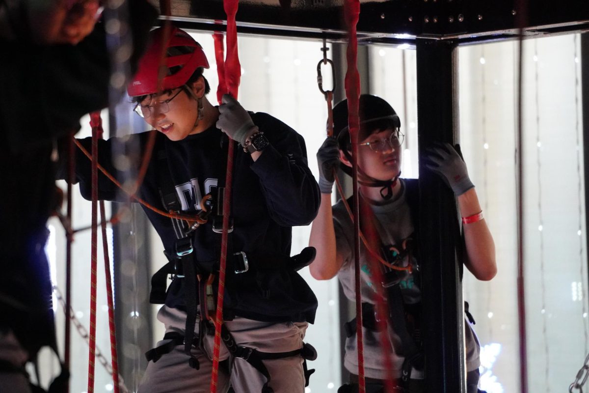 Juniors Oliver Park and Aiden Huh hover over the ropes to circle the entire floor. Participants wear safety equipment and navigate obstacles such as suspended ropes, balance beams and nets to finish the High Rope.