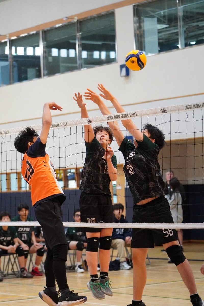 Middle Honglim Jin (2) and setter Aiden Hwang (18) rise together at the net to block the Tigers’ attempt to spike. Their synchronized block timing reflects the team’s strong preparation at the net. 