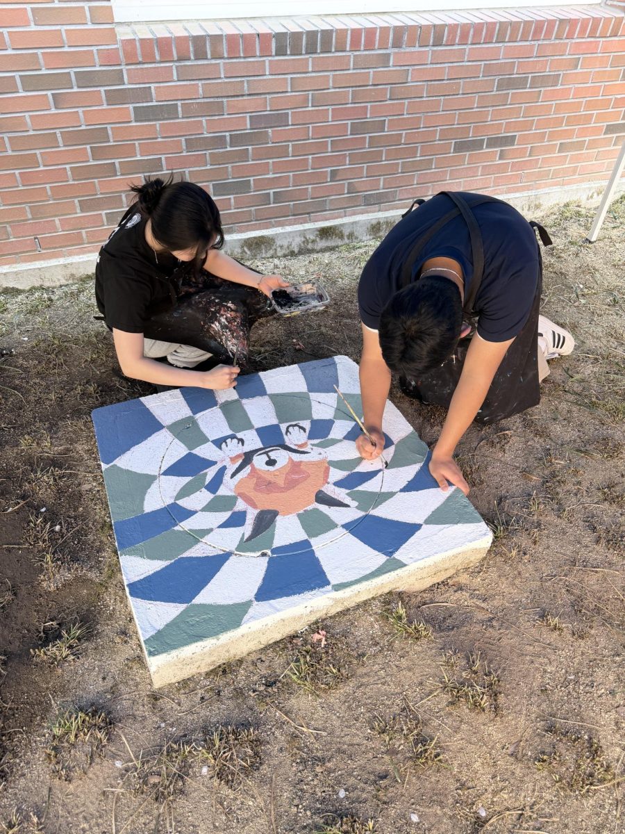 Senior Lily Lee and sophomore Lian Seok trace Glider’s outline with dark paint. With extreme dedication, they enhance the optical illusion.