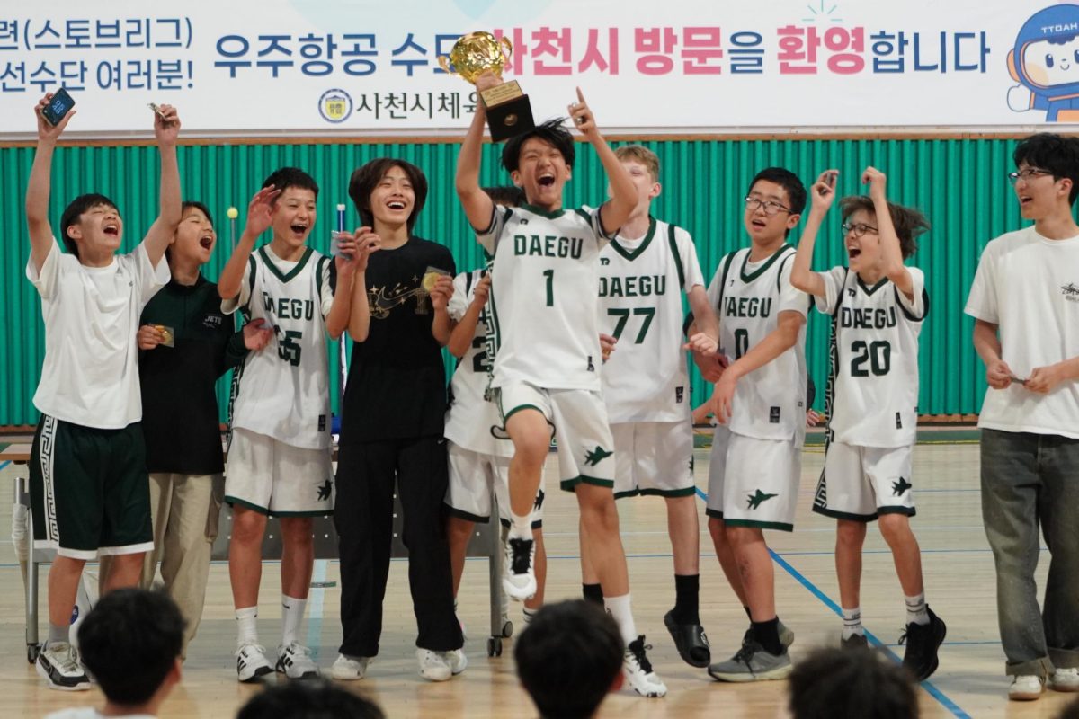 The junior varsity team erupts in celebration as they raise the championship trophy after a hard-fought tournament victory. Surrounded by cheering teammates, the Jets capture the excitement and pride of the team’s accomplishments.