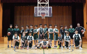 The DIS middle school boys basketball team gathers beneath the hoop as players and coaches prepare for the season ahead. With arms crossed and basketballs in hand, the Jets display confidence, unity and determination for the challenges ahead.