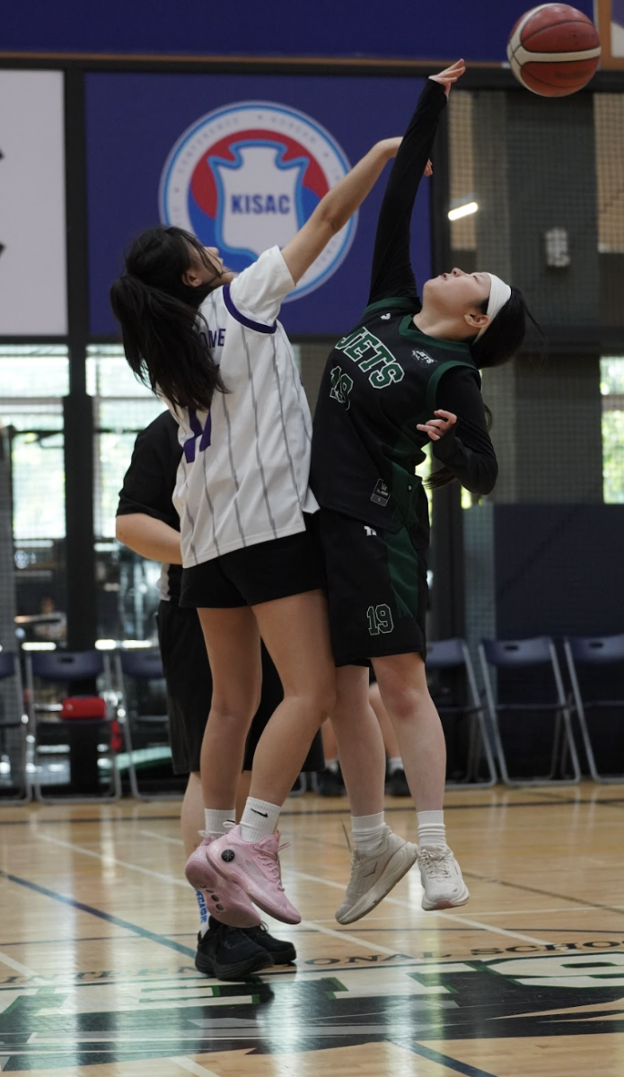 Mary Kong (19) takes the opening tip and directs the ball to her fellow teammate, allowing the Jets to gain possession and set the tone from the opening seconds. The successful tip allows the girls to establish its offense early and build momentum at the start of the game.