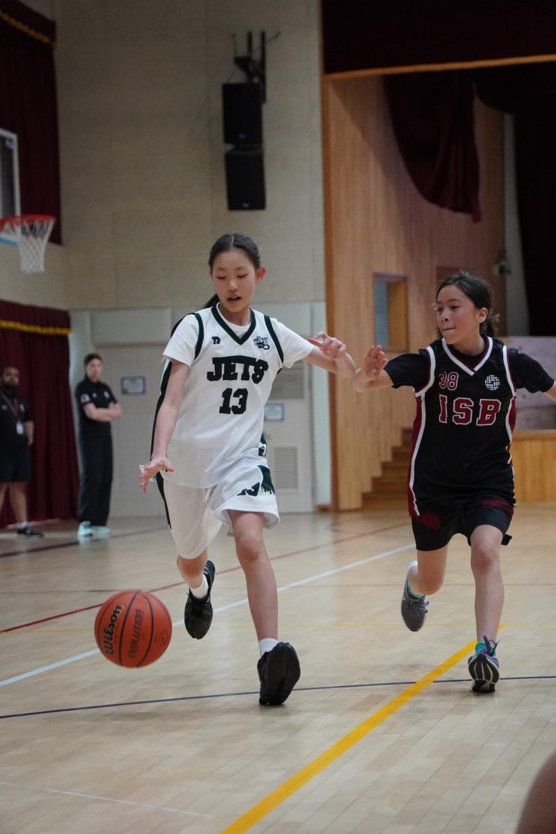 Joy Cha (13) grabs the rebound and pushes the ball up the sideline for a fast break. Cha sprints past her defender and drives to the open basket to finish at the rim for an easy layup. 
